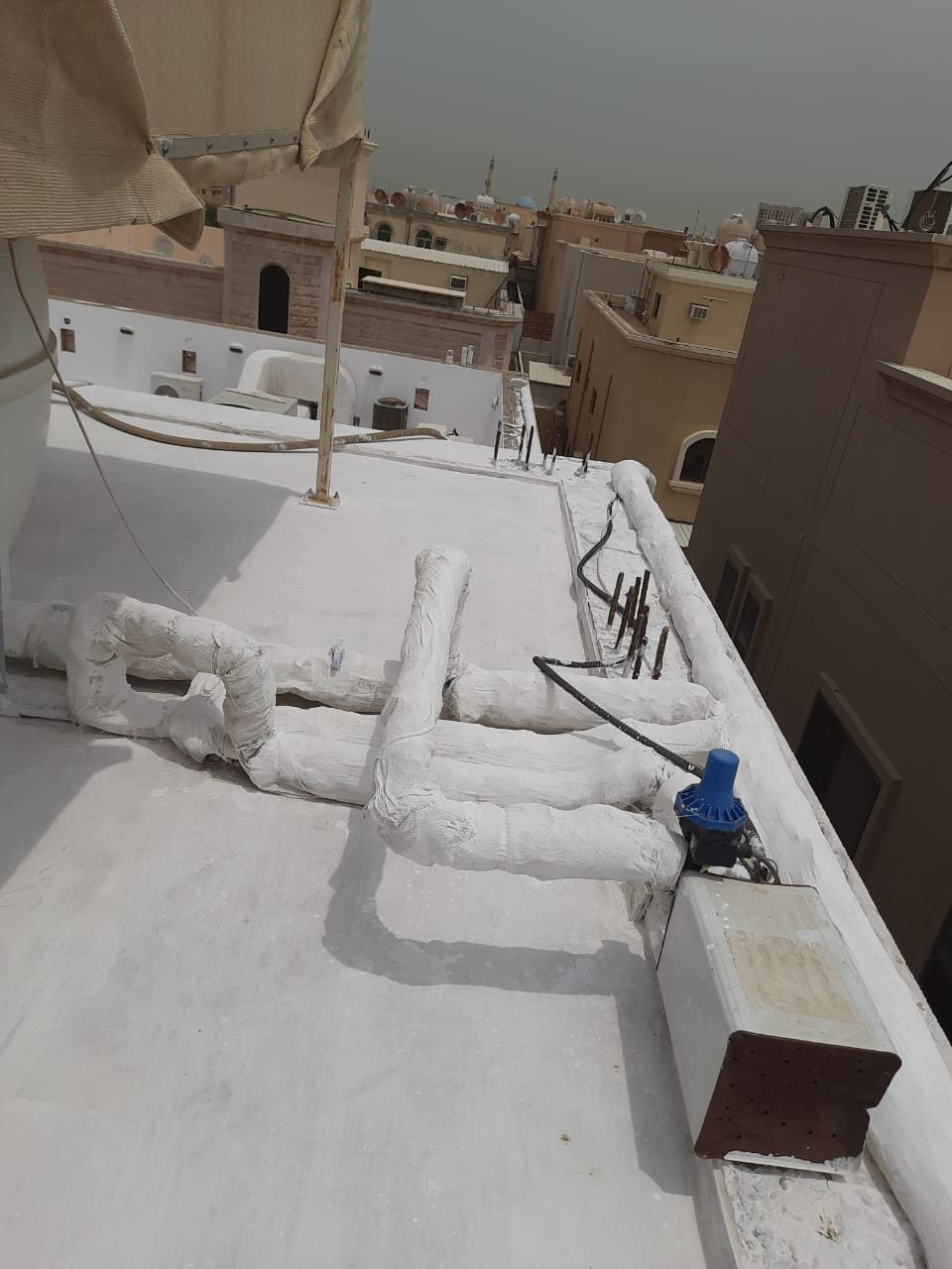 عزل مواسير وخطوط سطح بعزل أبيض